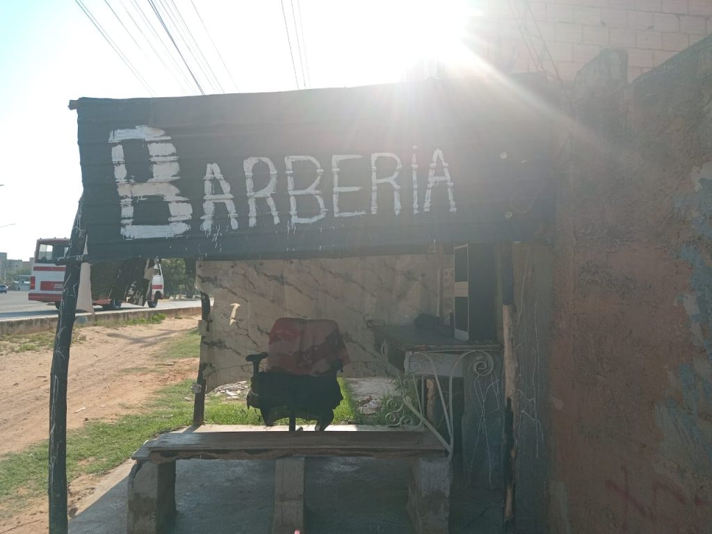 aviso hecho con lámina de zinc barberia como imagende fotorrepportaje de avisos callejeros latinoamericanos seccion encuadre del medio digital el-pajaro-azul.